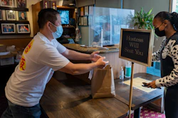 Benny Yun, owner of Yang Chow restaurant, left, delivers a take-out order in Los Angeles on Dec. 17.