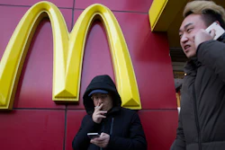 In this Jan. 10, 2017 file photo, a man smokes outside a McDonald's restaurant in Beijing, China.