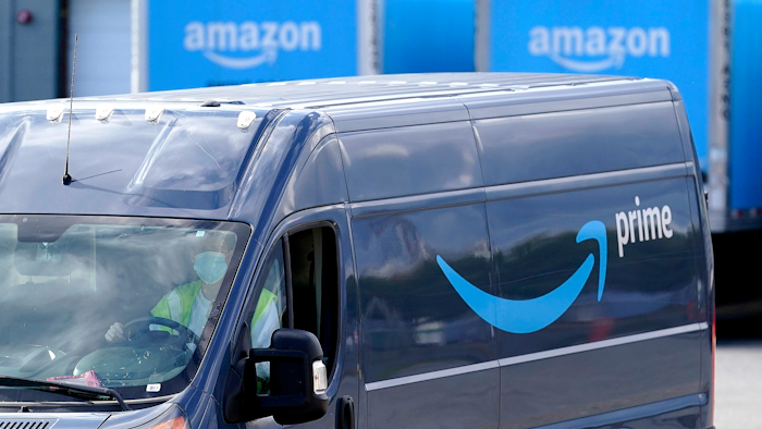 In this file photo, an Amazon Prime logo appears on the side of a delivery van as it departs an Amazon Warehouse. Online shopping has been a lifeline for many as the virus pandemic shuttered stores and kept people at home.