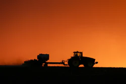 In this April 20, 2020, file photo, a farmer is silhouetted by the setting sun as a field is planted near Walford, IA.