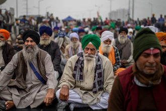 Farmers listen to a speaker as they block a major highway in protest against new farm laws, at the Delhi-Uttar Pradesh state border, India on Jan. 8.