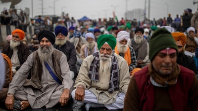 Farmers listen to a speaker as they block a major highway in protest against new farm laws, at the Delhi-Uttar Pradesh state border, India on Jan. 8.