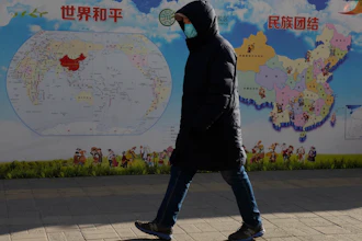 A man walks past a poster with the slogans 'World Peace' and 'Ethnic Unity' in Beijing, China on Jan. 11.