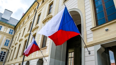 State flags of the Czech Republic on the facade of a government building in Prague.