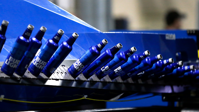 In this April 8, 2016, file photo, aluminum Bud Light bottles move along a conveyor at a plant manufacturing 16-ounce Budweiser and Bud Light aluminum bottles for Anheuser-Busch, in Arnold, MO.