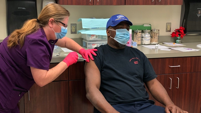 Melinda Tieskotter, supervisor of Perdue Farms' Accomac, Va. Wellness Center, administers the first round of the Moderna COVID-19 vaccine to live-haul associate James Edwards.