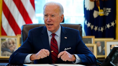 President Joe Biden signs a series of executive orders in the Oval Office, Jan. 28, 2021.