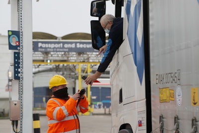 In this Jan 1 photo, a lorry driver's documents are scanned on a phone as he passes a checkpoint for the train through the Eurotunnel link with Europe in Folkestone, England.