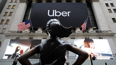 In this May 10, 2019 file photo, the statue of 'The Fearless Girl' in front of the New York Stock Exchange before Uber, the world's largest ride-hailing service, holds its initial public offering.