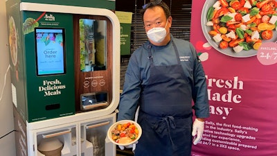 In this June 23, 2020 file photo, Kang Kuan, vice president of culinary at Chowbotics, holds a custom salad made by his company's robotic salad-making kiosk at the company's headquarters in Hayward, CA.