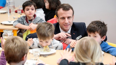 In this Jan.18, 2019 file photo, French President Emmanuel Macron meets pupils as he visits a school canteen in Saint-Sozy, southwestern France.