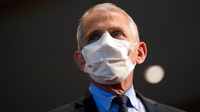 In this Dec. 22, 2020, file photo, Dr. Anthony Fauci, director of the National Institute of Allergy and Infectious Diseases, speaks before receiving his first dose of the COVID-19 vaccine at the National Institutes of Health, in Bethesda, Md. Fauci suggests fans enjoy the Super Bowl on Sunday, Feb. 7, 2021 with people in their household.