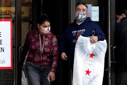 In this Dec. 19, 2020 file photo, Shoppers wear a mask as they leave a department store in Vernon Hills, Ill., The $600 stimulus checks got Americans shopping again. After three months of declines, retail sales soared a seasonally adjusted 5.3% in January from the month before, the U.S. Commerce Department said Wednesday, Feb. 17, 2021.