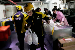Meituan delivery workers prepare orders in Beijing, March 1, 2016.