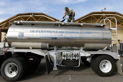 In this May 13, 2015 file photo, Rich Cain of the California Department of Fish and Wildlife, prepares a tanker truck filled with young salmon, called 'smolts' to be unloaded into a floating net suspended on a barge at Mare Island, Calif.