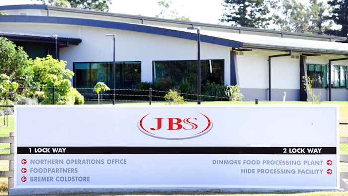 In this May 12, 2020 photo, the company logo sign sits at the entrance to the JBS Australia's Dinmore meatworks facility, west of Brisbane.