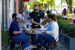 Patrons are assisted while dining along a sidewalk on Franklin Street in Chapel Hill, N.C. on April 16.