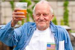 In this May 6 photo, George Ripley, 72, of Washington, holds up his free beer after receiving the J & J COVID-19 vaccine shot at The REACH at the Kennedy Center in Washington.