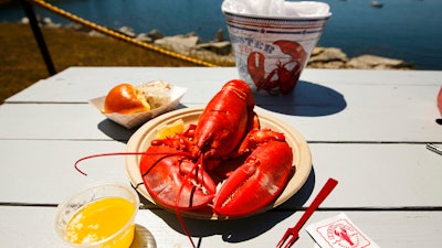 In this July 19, 2018 photo, a lobster is served waterfront at McLoon's Lobster Shack in Spruce Head, Maine.