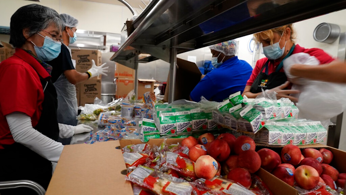 Los Angeles Unified School District food service workers from left, Tomoko Cho, Aldrin Agrabantes, April Thomas, and Marisel Dominguez, pre-package hundreds of free school lunches in plastic bags on Thursday, July 15, 2021, at the Liechty Middle School in Los Angeles. Flush with cash from an unexpected budget surplus, California is launching the nation's largest statewide universal free lunch program. When classrooms open for the fall term, every one of California's 6.2 million public school students will have the option to eat school meals for free, regardless of their family's income.