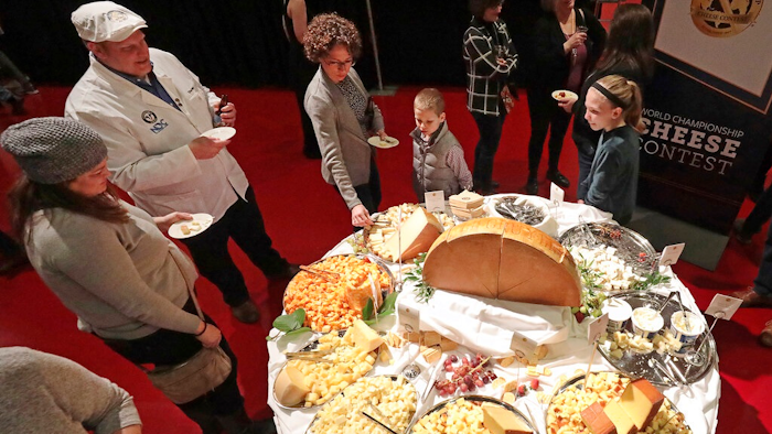 In this March 5, 2020 file photo, visitors to the Cheese Champion event of the World Championship Cheese Contest sample offerings from an array of international producers during the gathering at Monona Terrace in Madison, Wis. A bill being heard by a state Assembly committee would make colby, which was created in Wisconsin more than 100 years ago, the official stage cheese.