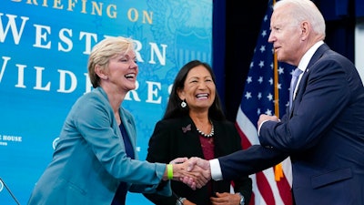 President Joe Biden, right, greets Energy Secretary Jennifer Granholm, left, and Interior Secretary Deb Haaland, center, before the start of an event in Washington, June 30, 2021.