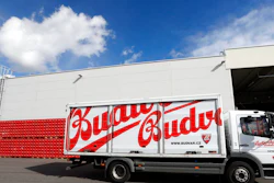 In this file photo taken Monday, March 11, 2019, a truck drives past cases of beer at the Budejovicky Budvar brewery in Ceske Budejovice, Czech Republic. Budvar, the Czech brewer that has been in a long legal dispute with U.S. giant Anheuser-Busch over use of the 'Budweiser' brand, increased its net profit by almost 10% last year amid record output as the pandemic saw people drink less in bars and more at home. Budejovicky Budvar NP, a 125-year-old state-owned brewery, said Monday July 12, 2021, its net profit reached 305 million crowns ($14 million) in 2020.