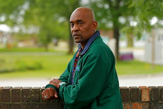 Crosby Smith, care provider at Ludeman Developmental Center, a state home for the developmentally disabled, poses for a portrait near the center premise, Thursday, July 8, 2021 in Park Forest, Ill. Smith and his fiancee were among numerous staff and residents at the Ludeman Developmental Center who contracted the virus last year. He said the hazard money helped pay down credit cards and avoid further debt when buying clothing and shoes.
