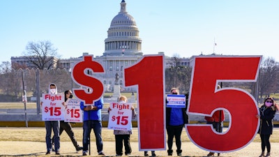 Activists appeal for a $15 minimum wage near the Capitol in Washington, Thursday, Feb. 25, 2021.