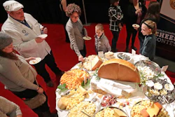 In this March 5, 2020 file photo, visitors to the Cheese Champion event of the World Championship Cheese Contest sample offerings from an array of international producers during the gathering at Monona Terrace in Madison, Wis. A bill being heard by a state Assembly committee would make colby, which was created in Wisconsin more than 100 years ago, the official stage cheese.