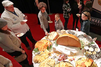 In this March 5, 2020 file photo, visitors to the Cheese Champion event of the World Championship Cheese Contest sample offerings from an array of international producers during the gathering at Monona Terrace in Madison, Wis. A bill being heard by a state Assembly committee would make colby, which was created in Wisconsin more than 100 years ago, the official stage cheese.