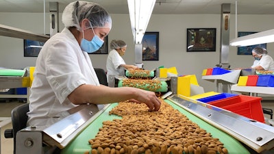 Employees inspect almonds in the processing facility at Steward & Jasper Orchards in Newman, Calif. on July 20.