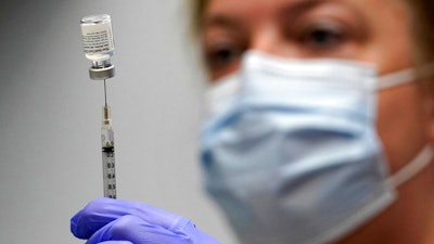 Pharmacy technician Hollie Maloney loads a syringe with Pfizer's COVID-19 vaccine at the Portland Expo in Portland, Maine, March 2, 2021.