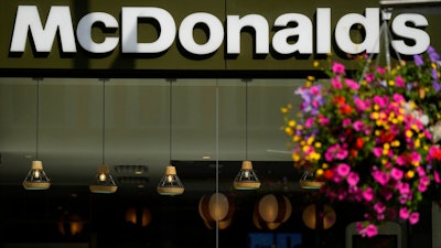 A customer walks in a McDonald's restaurant, in London, Tuesday, Aug. 24, 2021. McDonald’s says it has pulled milkshakes from the menu in all 1,250 of its British restaurants because of supply problems stemming from a shortage of truck drivers. The fast-food chain says it is also experiencing shortages of bottled drinks.