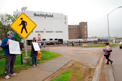 In this May 20, 2020 photo, residents cheer and hold thank-you signs to greet employees of a Smithfield pork processing plant as they begin their shift in Sioux Falls, S.D.