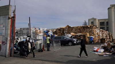 In this Feb. 18, 2021 photo, people walk inside a recycling location in Oakland, Calif.