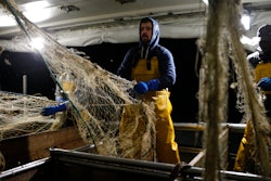 In this Dec. 10, 2020 photo, fisherman Nicolas Bishop works on the Boulogne sur Mer based trawler 'Jeremy Florent II' in Boulogne-sur-Mer, northern France.