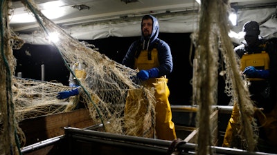 In this Dec. 10, 2020 photo, fisherman Nicolas Bishop works on the Boulogne sur Mer based trawler 'Jeremy Florent II' in Boulogne-sur-Mer, northern France.