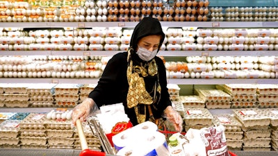 A woman shops in a supermarket in north Tehran, Iran, Saturday, Sept. 25, 2021. As U.S. sanctions strangle Iran's economy, record inflation is causing stunned shoppers in the country to cut meat and dairy from their diets and to purchase less each month.