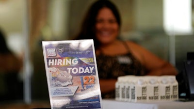 A hiring sign is placed at a booth for prospective employers during a job fair Wednesday, Sept. 22, 2021, in the West Hollywood section of Los Angeles. The number of Americans applying for unemployment aid rose last week for a second straight week to 351,000, a sign that the delta variant of the coronavirus may be disrupting the job market’s recovery, at least temporarily.