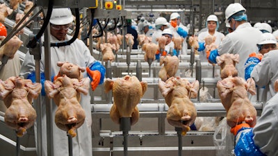 In this Dec. 12, 2019 photo, workers process chickens at a poultry plant, in Fremont, NE.
