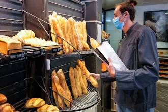 Baker Hugo Hardy prepares baguettes to be sold at Bigot bakery in Versailles, west of Paris on Oct. 26, 2021.