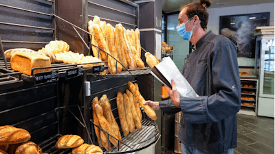 Baker Hugo Hardy prepares baguettes to be sold at Bigot bakery in Versailles, west of Paris on Oct. 26, 2021.