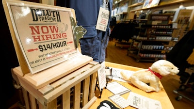 A now hiring sign sits on a display in a clothing store Saturday, Oct. 9, 2021, in Sioux Falls, S.D. The number of Americans applying for unemployment benefits fell to its lowest level since the pandemic began, a sign the job market is still improving even as hiring has slowed in the past two months.