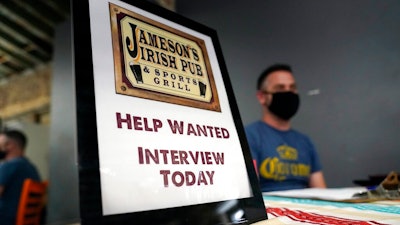 In this Sept. 22, 2021, file photo, a hiring sign is placed at a booth for Jameson's Irish Pub during a job fair in the West Hollywood section of Los Angeles. California's historic hiring slowed down in September as the state added 47,400 new jobs. California has been averaging more than 100,000 new jobs each month since February. New data released Friday, Oct. 22, 2021, by the U.S. Bureau of Labor Statistics shows California is now tied with Nevada for the highest unemployment rate in the country at 7.5%.