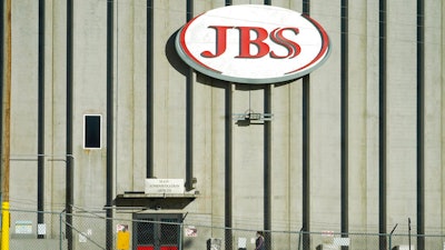 In this Oct. 12, 2020 file photo, a worker heads into the JBS meatpacking plant in Greeley, Colo. Meatpacker JBS Foods Inc. faces about $59,000 in fines after a worker fell into vat of chemicals used to process animal hides and died at one of the company's meat processing facilities in northern Colorado, officials said.