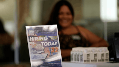 A hiring sign is placed at a booth for prospective employers during a job fair Wednesday, Sept. 22, 2021, in the West Hollywood section of Los Angeles. The number of Americans applying for unemployment aid rose last week for a second straight week to 351,000, a sign that the delta variant of the coronavirus may be disrupting the job market’s recovery, at least temporarily.