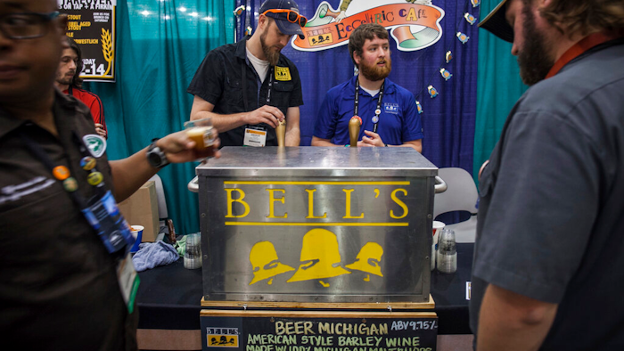 Andrew Koehring, left, and Ryan Sherman, right, of Bell's Brewery serve beer samples during the 36th Annual American Homebrewers Assocation National Homebrewers Conference at DeVos Place in Grand Rapids, MI on June 12, 2014.