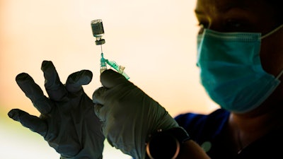 In this Sept. 14, 2021 photo, a syringe is prepared with the Pfizer COVID-19 vaccine at a clinic at the Reading Area Community College in Reading, Pa.