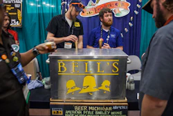 Andrew Koehring, left, and Ryan Sherman, right, of Bell's Brewery serve beer samples during the 36th Annual American Homebrewers Assocation National Homebrewers Conference at DeVos Place in Grand Rapids, MI on June 12, 2014.